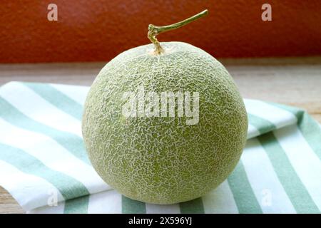 Fresh Ripe Muskmelon or Cantaloupe Melon Fruit Isolated on Striped Dish Towel Stock Photo