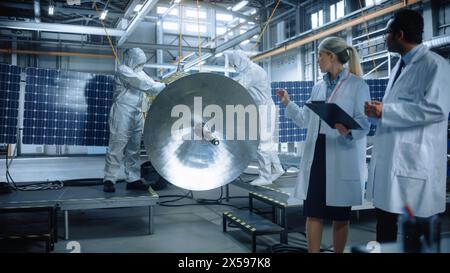 Team of Engineers Working on Satellite Construction, Use Tablet Computer Talk about Data. Aerospace Spaceship Manufacturing Facility: Team of Scientists Building Spacecraft for Space Exploration Stock Photo