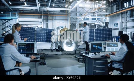 Team of Engineers Working on Satellite Construction. Aerospace Agency Spaceship Manufacturing Factory. Group of Multi-Ethnic Scientists Developing Spacecraft. World Space Exploration Program Stock Photo