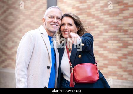Happy friends or couple walking, pointing at smart hotel location outdoors. Stock Photo