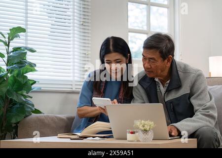 married retired senior couple checking and calculate financial billing together on sofa Stock Photo