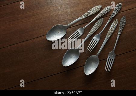 Three pairs of old silver cutlery with different classic carved ornaments on the handles Stock Photo