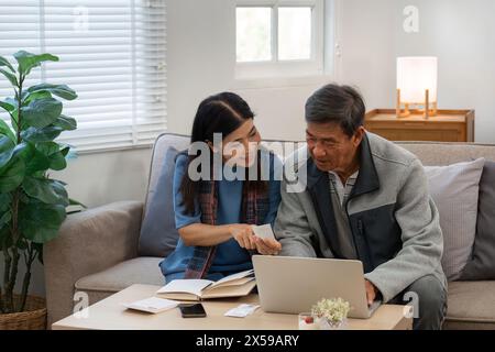 married retired senior couple checking and calculate financial billing together on sofa Stock Photo