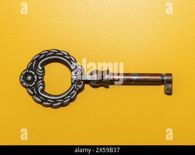 old bookcase key on a colored background, old brass key Stock Photo