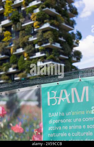 Milan, Lombardy, Italy - MAY, 5, 2024: the BAM - Biblioteca degli Alberi park sign with the nearby Bosco Verticale in the background. Stock Photo