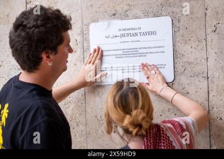 Rome, Rm, Italy. 8th May, 2024. Students and professors gather in front of the memorial plaque, placed last week at the entrance of Physics Faculty, to remember Sufian Tayeh (Palestinian physicist, rector of Gaza University, killed last December during bombing of Gaza). The plaque has been vandalized yesterday by a group of masked people. ''Israel'' and stars of David have also been painted on the wall. Two students replace the plaque with a temporary paper copy of the original. (Credit Image: © Marco Di Gianvito/ZUMA Press Wire) EDITORIAL USAGE ONLY! Not for Commercial USAGE! Stock Photo