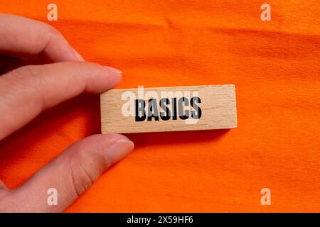 Basics word written on wooden block with orange background. Conceptual basics word symbol. Copy space. Stock Photo