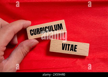 Curriculum vitae words written on wooden blocks with red background. Conceptual curriculum vitae CV symbol. Copy space. Stock Photo