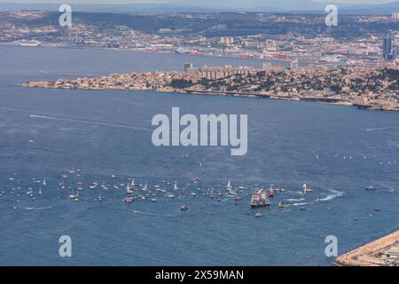 Marseille, France. 8th May, 2024. The Belem, carrying the Olympic flame, arrives in Marseille. The three-masted sailing ship is greeted by a fleet of boats and thousands of spectators ashore. The Olympic flame was lit on 16th April in Olympia, and left Greece aboard the Belem on 27th April. The torch will now traverse the mainland and overseas France before the opening ceremony on 26th July in Paris. Credit: Viktor Sip/Alamy Live News Stock Photo