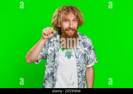 Knock-knock who is there. Confused excited young man knocking door gesture asking who is at home, feeling embarrassed, no idea, being clueless and uncertain. Guy isolated on chroma key background Stock Photo