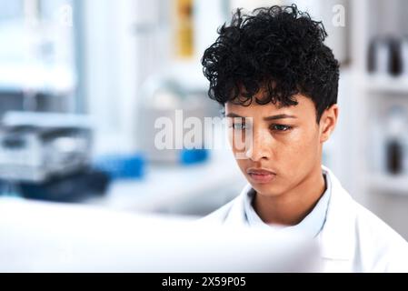 Female scientist, thinking and computer in lab for research, clinical trial or biotechnology or chemistry. Woman, chemist or studying in center for Stock Photo