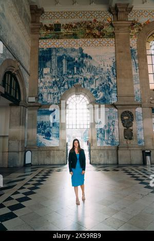 sao bento railway station with beautifully decorated blue and white azulejo tiles in Porto Portugal with a tourist woman Stock Photo