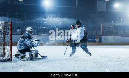 Ice Hockey Rink Arena: Goalie is Ready to Defend Score against Forward Player who Shoots Puck with Stick. Forwarder against Goaltender One on One. Tension Moment in Sport Full of Emotions. Stock Photo