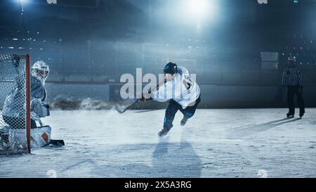 Ice Hockey Rink Arena: Goalie is Ready to Defend Score against Forward Player who Shoots Puck with Stick. Forwarder against Goaltender One on One. Tension Moment in Sport Full of Emotions. Stock Photo