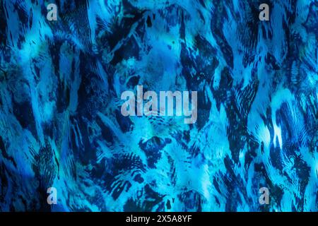 An intricate abstract background with patterns of blue and black resembling watercolor brush strokes on a textured surface. Stock Photo