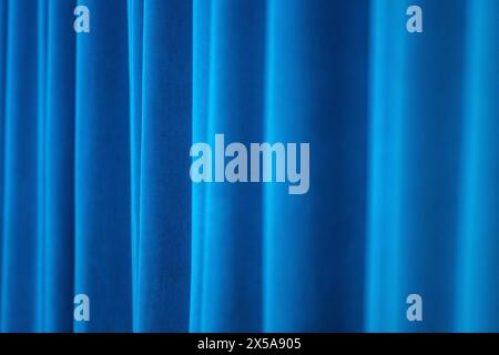 This image captures the luxurious texture of velvet curtains in a blue hue, creating a soothing and elegant abstract background. Stock Photo