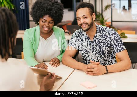 Diverse team engaged in a discussion at a modern coworking space Stock Photo