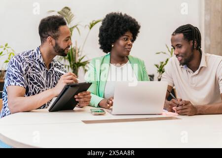 A multiethnic group of professionals collaborating on a project in a bright coworking space, focusing intently on their tasks Stock Photo
