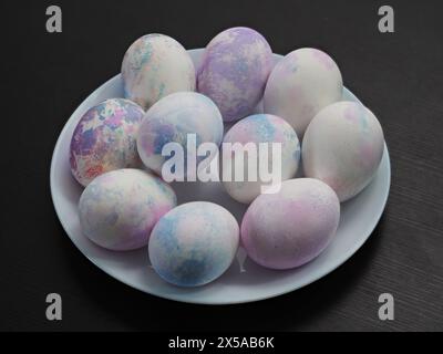 Hand painted with markers for drawing, decorated easter eggs on white plate. Stock Photo