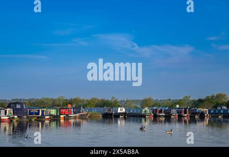 Dunchurch Pools Marina, Warwickshire, Oxford Canal – Summer morning  narrowboats in tranquil surroundings against a clear blue sky Stock Photo