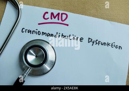 Concept of CMD - Craniomandibulare Dysfunktion write on sticky notes isolated on Wooden Table. Stock Photo