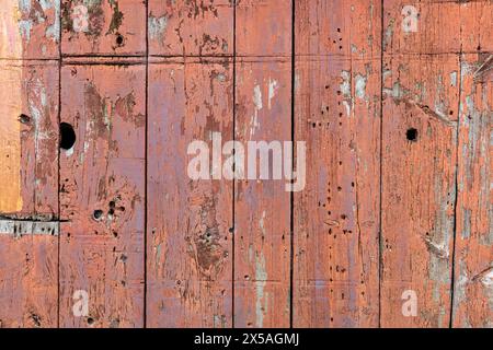 Abstract detail surface of a section of the wooden boards of an old, red, weathered barn. Stock Photo
