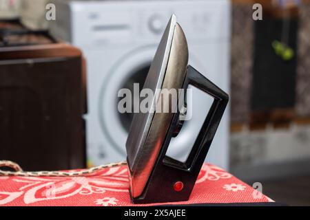A black iron representing Automotive design is displayed on a red tablecloth alongside wood representing Auto parts in a stylish setting Stock Photo