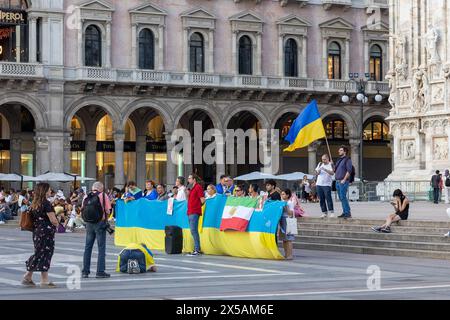 Milan, Italy - July 27 2023: Public gathering in support of Ukraine on square in front the dome. Man holding Ukranian flag. Tourists visible Stock Photo