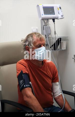 Patient wearing Face Mask having Blood Pressure Tested before Chemotherapy Treatment At Hospital Surrey England Stock Photo