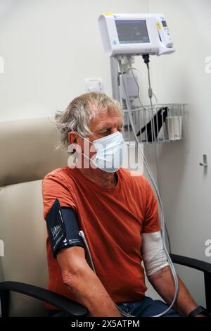 Patient wearing Face Mask having Blood Pressure Tested before Chemotherapy Treatment At Hospital Surrey England Stock Photo