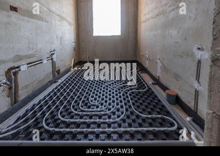 View of a modern underfloor heating system with pipes and insulation before concrete pouring Stock Photo