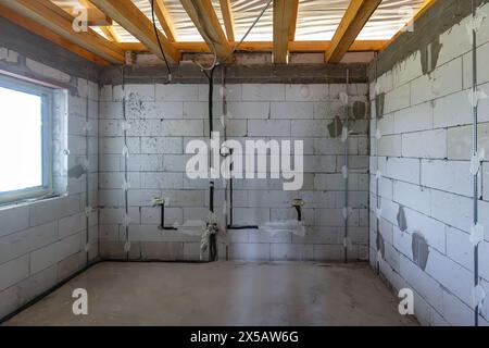 Spacious basement in the midst of construction, with exposed pipes and beams Stock Photo