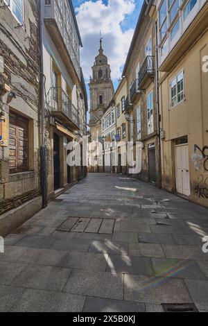 Lugo, Spain - April 29, 2024: Buildings with a history of their own frame a path that culminates in the majestic cathedral tower. Stock Photo