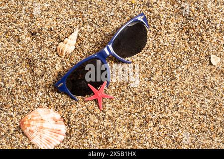 Summer background with sunglasses, seashells and starfish on sand Stock Photo