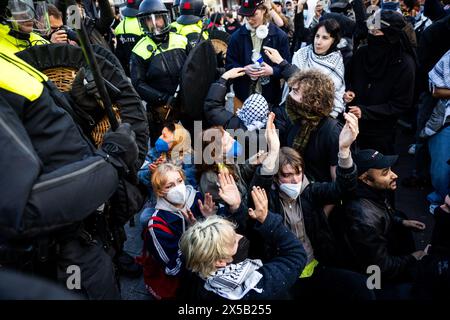 AMSTERDAM - Police officers try to stop support demonstrators on the Rokin. In the morning, the barricades erected by demonstrators at the Binnengasthuis grounds of the University of Amsterdam (UvA) are still visible. Entrances to the site are blocked from several sides with, among other things, pallets and bicycle racks. ANP RAMON VAN FLYMEN netherlands out - belgium out Stock Photo