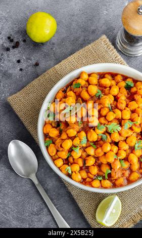 Indian Chickpea Curry with lemon in a Bowl Garnished with Cilantro Stock Photo