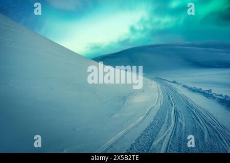 Fantastic Aurora borealis, Northern lights glowing over snow covered mountain on glacier summit in Arctic Circle Stock Photo