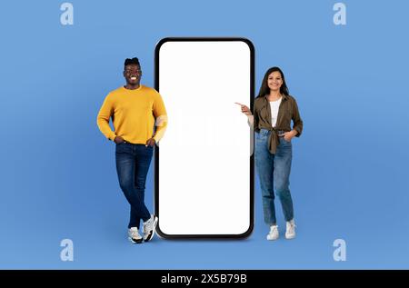 Two People Standing Next to a Large Phone Stock Photo