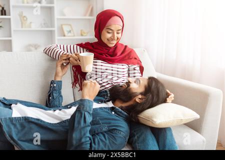 A Man Laying on a Couch Next to a Woman Stock Photo
