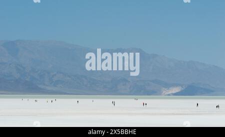 People walking on the Bad Water Basin salt flats where Lake Manly formed after torrential rains Stock Photo