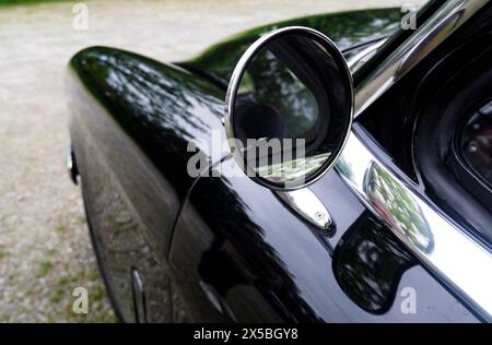 Driver's side rear view mirror of a 1955 Studebaker President. The Studebaker President was the premier automobile model manufactured by the Studebake Stock Photo