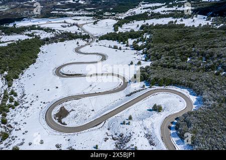 Mountain pass down to village Villa Cerro Castillo, aerial view of serpentines in snow-covered landscape, Patagonia, Chile Stock Photo