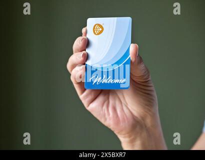 BEMIDJI, MN - 20 JUL 2020: Womans hand holding FID generic hotel room security keycard in close-up view. Stock Photo