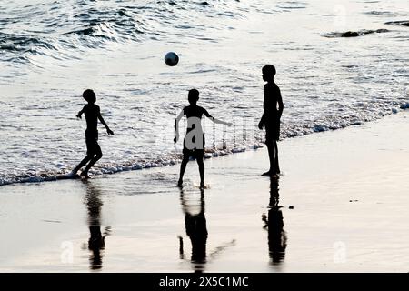 Salvador, Bahia, Brazil - February 14, 2019: Young people are seen, in silhouette, playing beach soccer in the city of Salvador, Bahia. Stock Photo