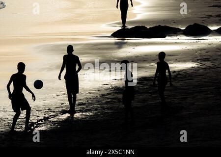 Salvador, Bahia, Brazil - February 14, 2019: People are seen playing beach soccer on Ondina beach during sunset in Salvador, Bahia. Stock Photo