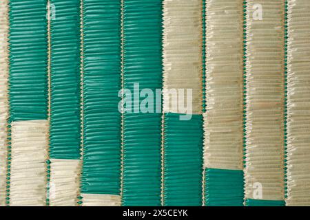 plastic woven straw reed mat surface background, abstract of handmade plaited reeds textured wallpaper or backdrop of beach picnic floor covering Stock Photo