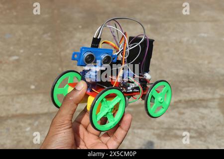 Robotic car project made using 3d printing technology and also the use of different electronic components held in the hand Stock Photo