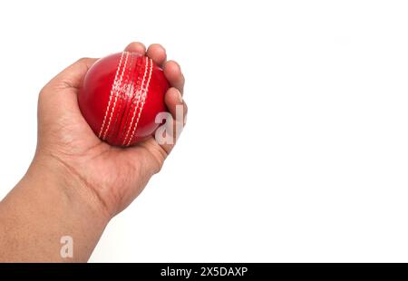 red cricket leather ball in bowler hand on the white background Stock Photo