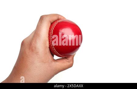 red cricket leather ball in bowler hand on the white background Stock Photo