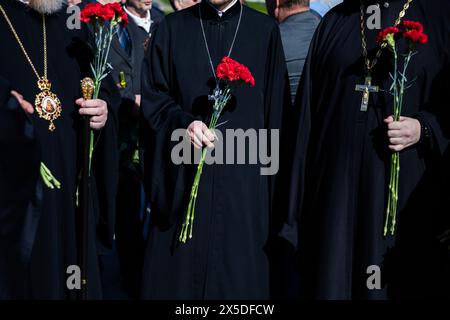Berlin, Germany. 09th May, 2024. Russian Orthodox clergymen hold flowers at the Soviet memorial in Treptow Park. May 8 and 9 marks the 79th anniversary of the liberation from National Socialism. Credit: Christoph Soeder/dpa/Alamy Live News Stock Photo